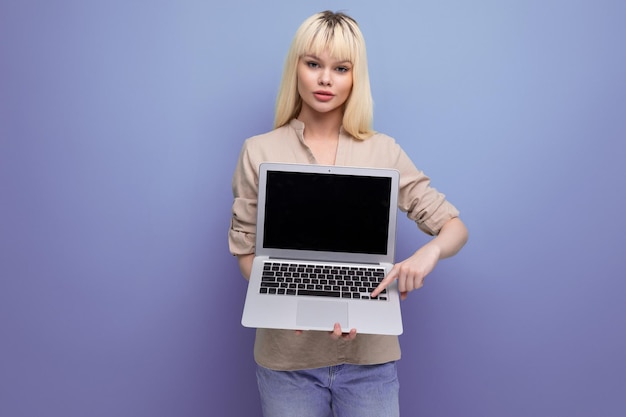 Mujer de negocios joven rubia exitosa con maqueta de pantalla de computadora portátil