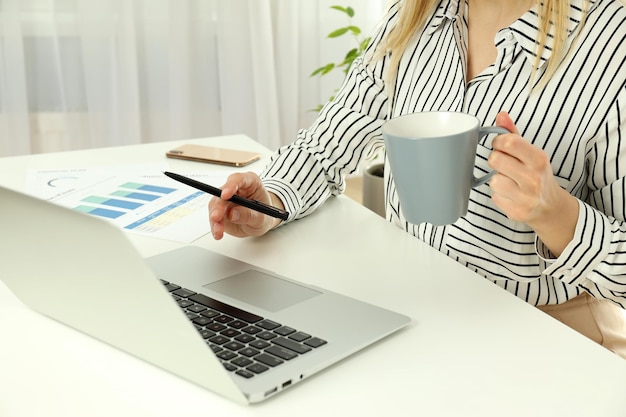 Mujer de negocios joven sentada en el lugar de trabajo o mesa de trabajo