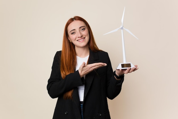 Mujer de negocios joven sosteniendo un concepto de energía limpia de molino de viento