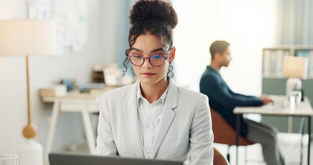 Mujer de negocios leyendo en la computadora y planeando investigación en línea o editando un informe legal para un bufete legal o de abogados Jóvenes profesionales o abogados en el espacio de trabajo portátil y gafas para el análisis