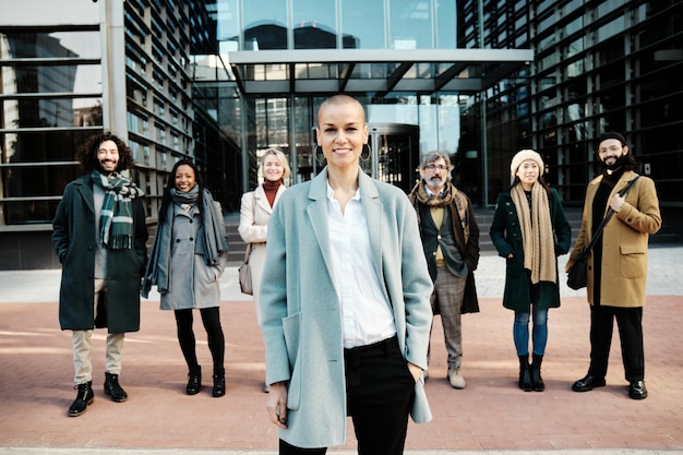 Foto mujer de negocios líder que se destaca de un grupo de empresarios mientras está de pie en el distrito financiero.