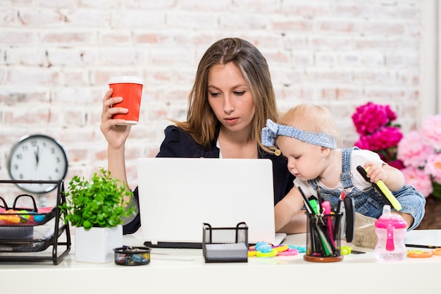 Foto mujer de negocios, madre, mujer, con, un, hija, trabajo en la computadora