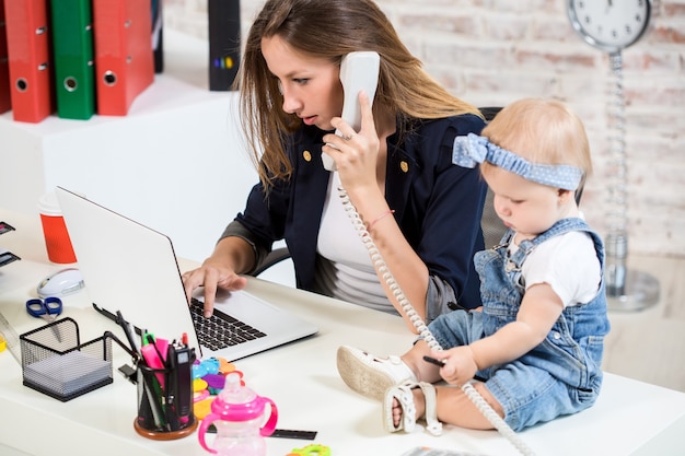 Foto mujer de negocios, madre, mujer, con, un, hija, trabajo en la computadora