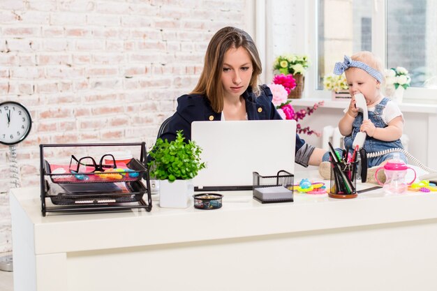 Mujer de negocios, madre, mujer, con, un, hija, trabajo en la computadora