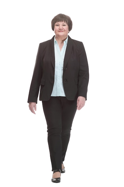 Mujer de negocios madura en un traje pantalón caminando hacia adelante