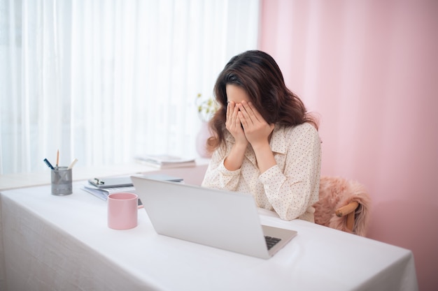 Mujer de negocios de mal humor falló y tiene problemas mientras trabajaba con la computadora portátil