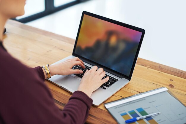 Mujer de negocios y manos con computadora portátil en la oficina para analizar la tabla de ingresos o el gráfico de estrategia para revisar el informe financiero Gente corporativa y papel para la investigación con estadísticas para el crecimiento de la empresa