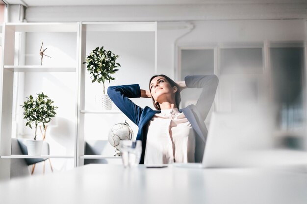 mujer de negocios, en la mesa, reclinado hacia atrás