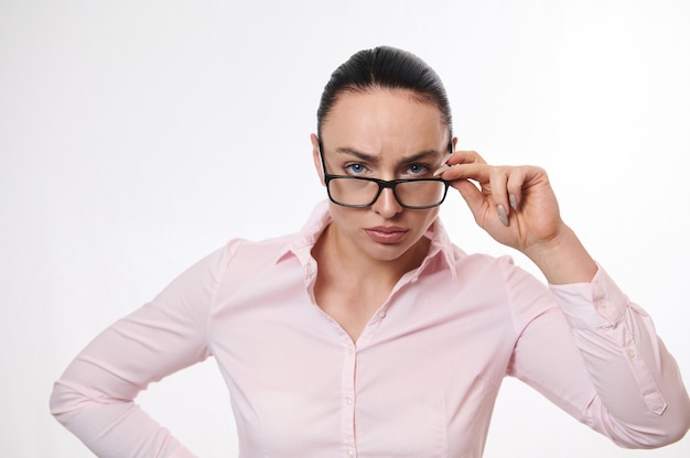 Mujer de negocios mirando a la cámara a través de anteojos bajados. Retrato aislado sobre fondo blanco con espacio de copia