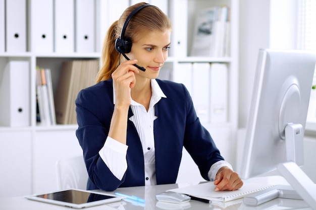 Mujer de negocios moderna con auriculares en la oficina.