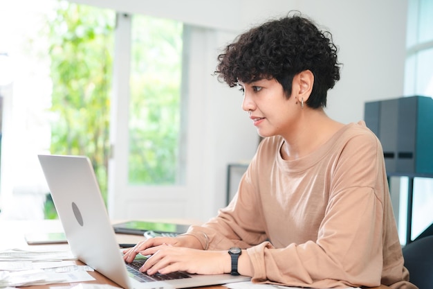 Mujer de negocios moderna que trabaja desde casa Mujer joven emprendedora que utiliza la computadora portátil para un proyecto independiente