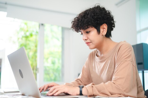 Mujer de negocios moderna que trabaja desde casa Mujer joven emprendedora que utiliza la computadora portátil para un proyecto independiente