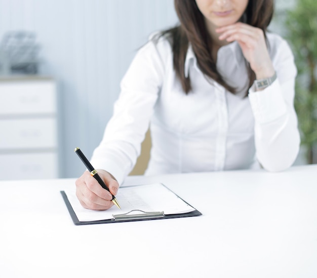 Mujer de negocios moderna que trabaja con documentos en el lugar de trabajo en la oficina