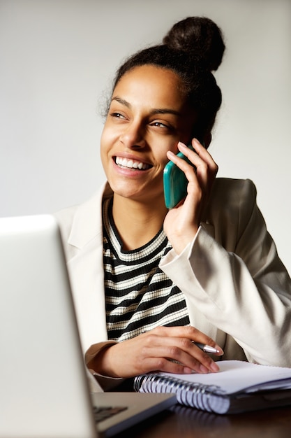 Mujer de negocios moderna sonriendo y hablando por teléfono móvil
