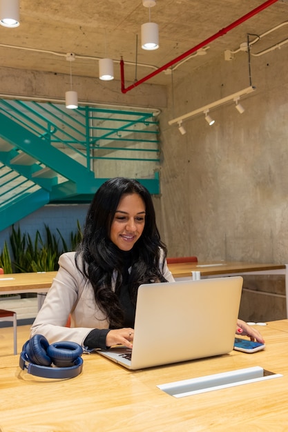 Mujer de negocios morena trabajando desde su espacio de trabajo