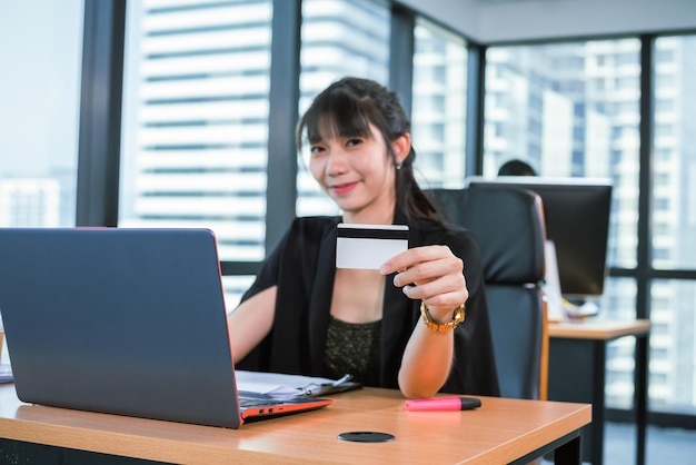 Mujer de negocios mostrar tarjeta de presentación en la oficina moderna