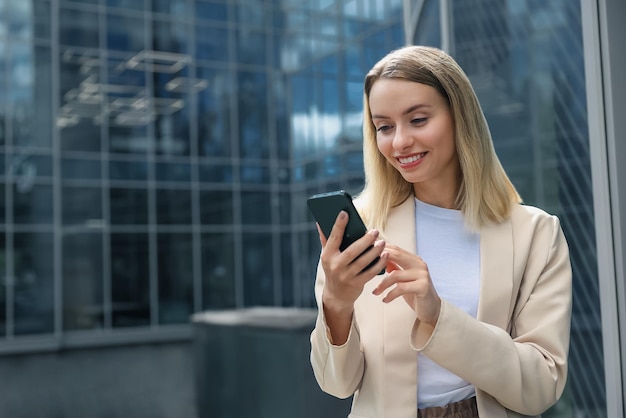 Mujer de negocios. Mujer rubia de pelo largo con un teléfono en la mano