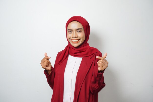 Mujer de negocios musulmana asiática con ropa informal roja que señala el saludo de amor al estilo coreano