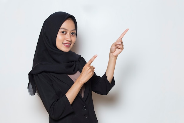 Mujer de negocios musulmana asiática señalando con el dedo a diferentes direcciones copia espacio para publicidad