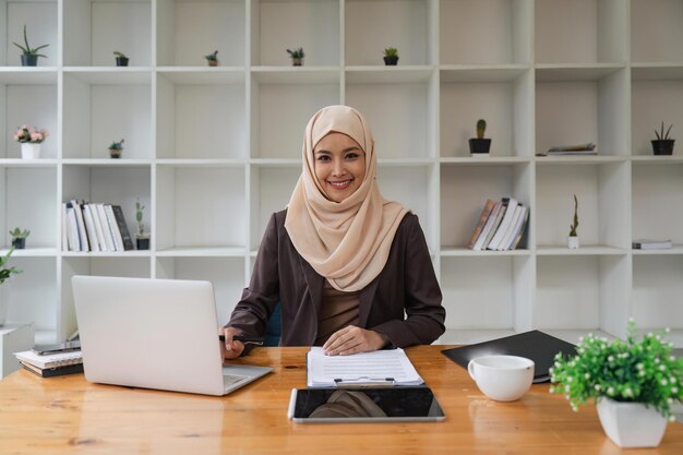 Mujer de negocios musulmana asiática sentada en la oficina moderna gente de negocios diversidad y concepto de oficina