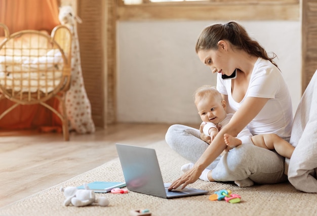 Mujer de negocios con un niño trabajando desde casa usando un teléfono portátil