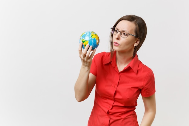 Mujer de negocios o profesor triste conmocionada en camisa roja sosteniendo en las palmas Globo terráqueo aislado sobre fondo blanco. Problema de contaminación ambiental. Detener la basura de la naturaleza, el concepto de protección del medio ambiente.