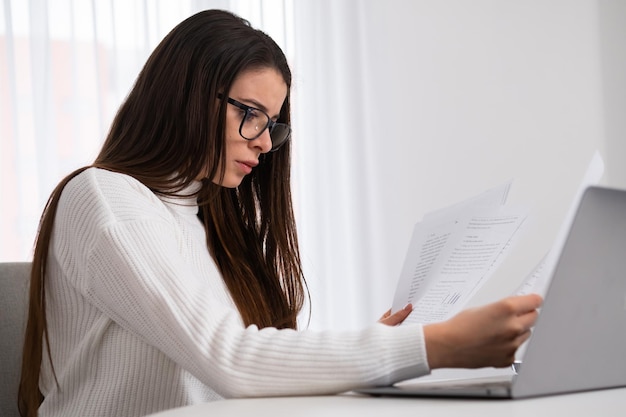 Mujer de negocios ocupada trabajando con documentos y cuaderno