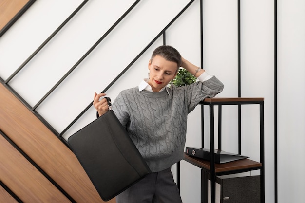 Mujer de negocios en la oficina con un maletín de cuero para documentos en sus manos