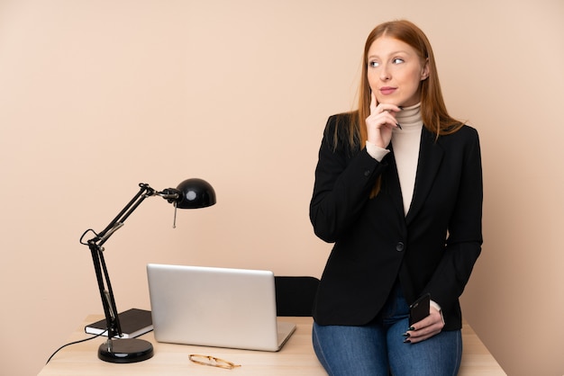 Mujer de negocios en una oficina pensando en una idea