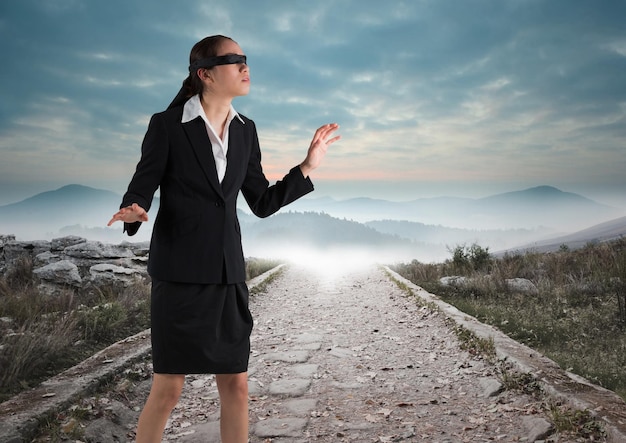 Mujer de negocios con los ojos vendados caminando por la carretera