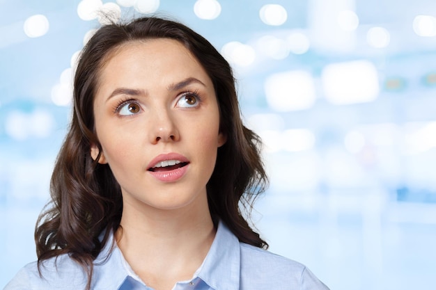 Mujer de negocios de pensamiento que mira para arriba