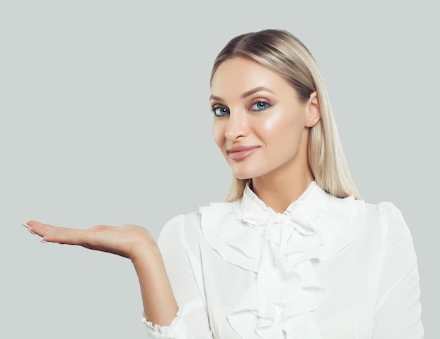 Mujer de negocios perfecta que muestra la mano abierta vacía sobre fondo blanco Empresaria sonriendo concepto de negocios y educación