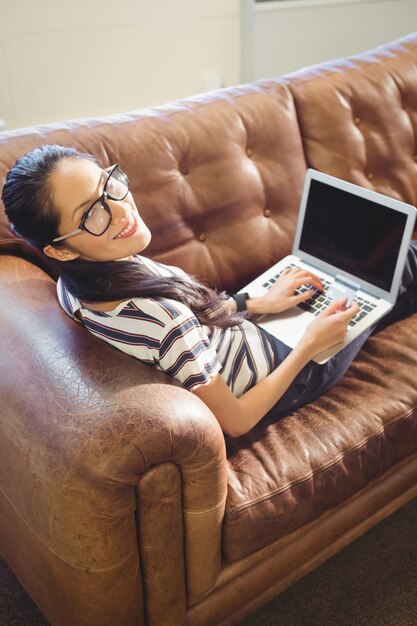 Mujer de negocios posando delante de su computadora con su tarjeta