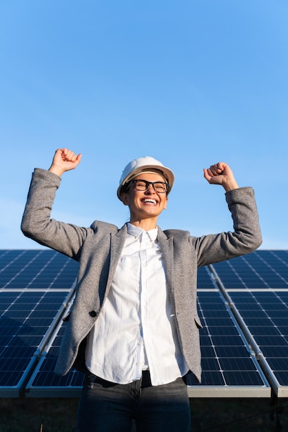 Mujer de negocios positiva con una linda sonrisa disfrutando del triunfo con energía ecológica