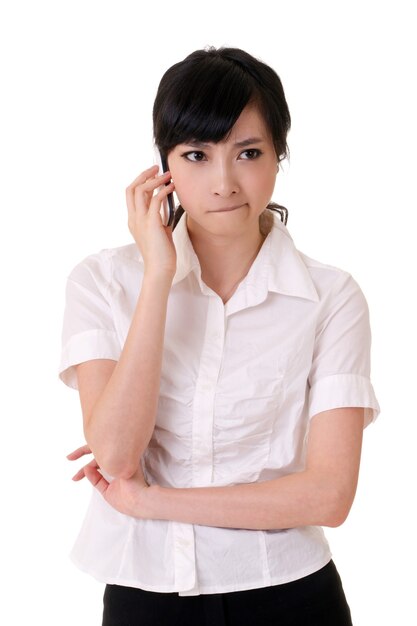 Mujer de negocios preocupada sosteniendo teléfono celular y escuchando sobre fondo blanco.