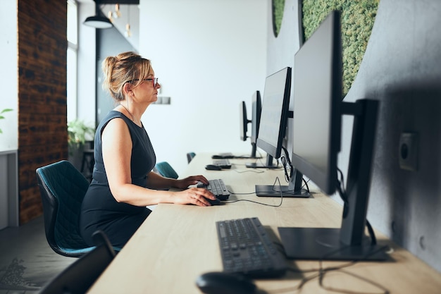 Mujer de negocios preocupada trabajando en la computadora en la oficina mujer ocupada sentada en el escritorio frente a la pantalla