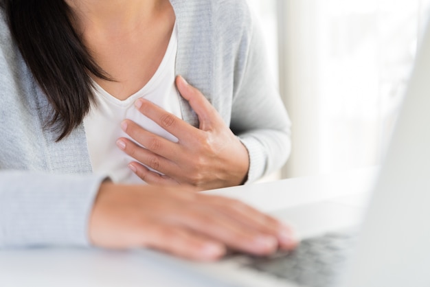 Mujer de negocios del primer que tiene ataque del corazón. Síndrome de oficina