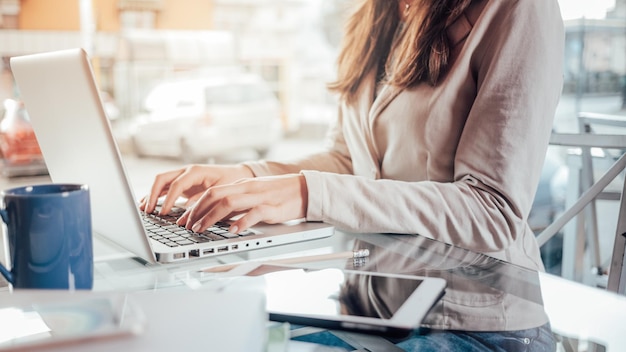 Mujer de negocios profesional en el trabajo con las manos de la computadora portátil de cerca