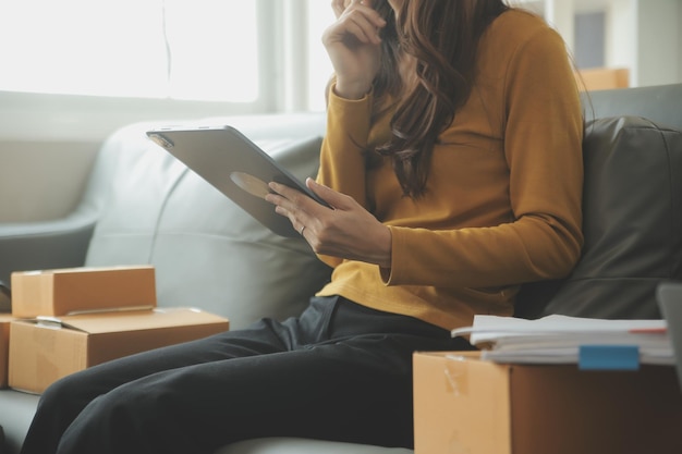 Mujer de negocios puesta en marcha emprendedora de pequeñas empresas SME éxito mujer independiente que trabaja en casa con entrega de paquetes en línea SME y concepto de entrega de embalaje