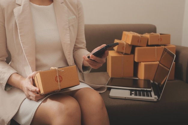 Mujer de negocios puesta en marcha emprendedora de pequeñas empresas SME éxito mujer independiente que trabaja en casa con entrega de paquetes en línea SME y concepto de entrega de embalaje