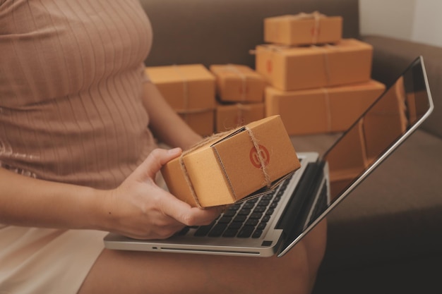 Mujer de negocios puesta en marcha emprendedora de pequeñas empresas SME éxito mujer independiente que trabaja en casa con entrega de paquetes en línea SME y concepto de entrega de embalaje