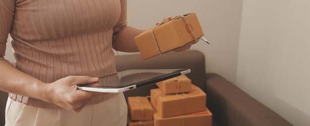 Mujer de negocios puesta en marcha emprendedora de pequeñas empresas SME éxito mujer independiente que trabaja en casa con entrega de paquetes en línea SME y concepto de entrega de embalaje