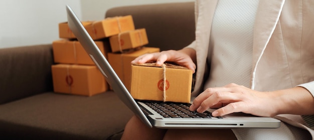 Mujer de negocios puesta en marcha emprendedora de pequeñas empresas SME éxito mujer independiente que trabaja en casa con entrega de paquetes en línea SME y concepto de entrega de embalaje