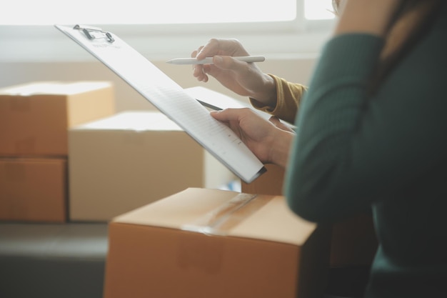 Mujer de negocios puesta en marcha emprendedora de pequeñas empresas SME éxito mujer independiente que trabaja en casa con entrega de paquetes en línea SME y concepto de entrega de embalaje