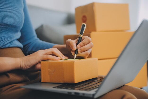 Mujer de negocios puesta en marcha emprendedora de pequeñas empresas SME éxito mujer independiente que trabaja en casa con entrega de paquetes en línea SME y concepto de entrega de embalaje