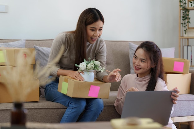 Mujer de negocios PYME asiática con un socio que trabaja en el concepto de compras en línea de la oficina en casa