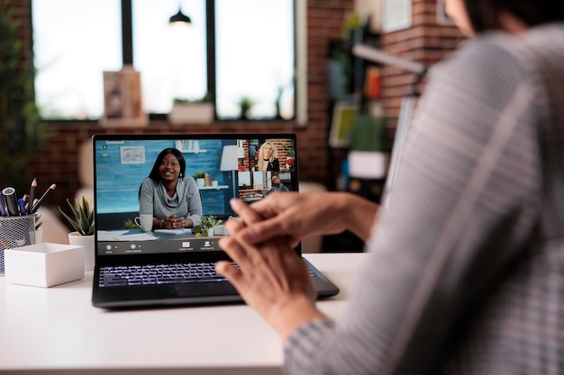 Mujer de negocios que asiste a una reunión de videollamada en línea con colegas en la cámara web, hablando con personas en una llamada virtual de teleconferencia. Charlando por videoconferencia remota de telecomunicaciones.