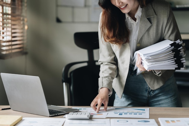 Mujer de negocios que calcula los impuestos de las facturas y el saldo de la cuenta de ahorro Concepto de finanzas