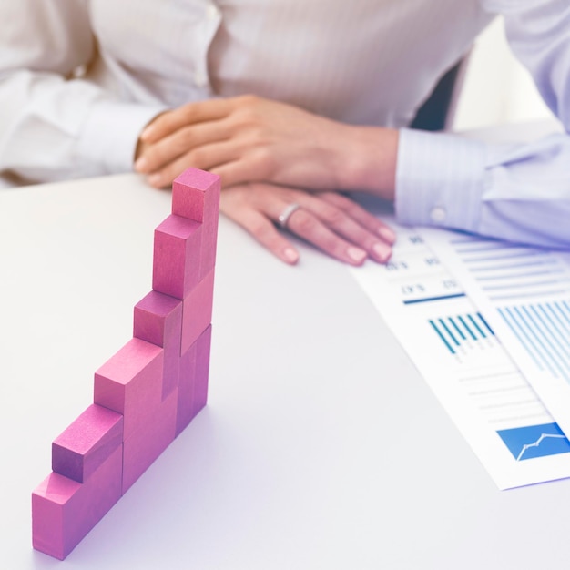 Foto mujer de negocios que construye un gráfico financiero en crecimiento con piezas de madera desarrollo y concepto de estrategia