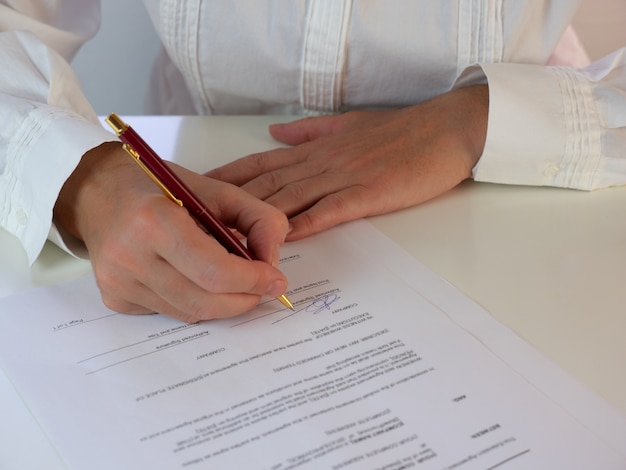 Foto mujer de negocios que firma un documento oficial o un contrato. centrarse en la firma